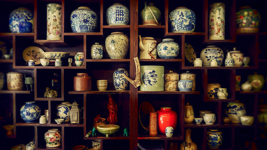 A shelf full of beautiful china vases.